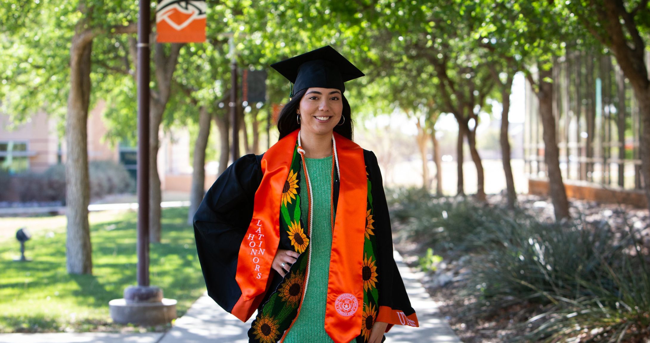Ariana Flores smiling at camera wearing her regalia