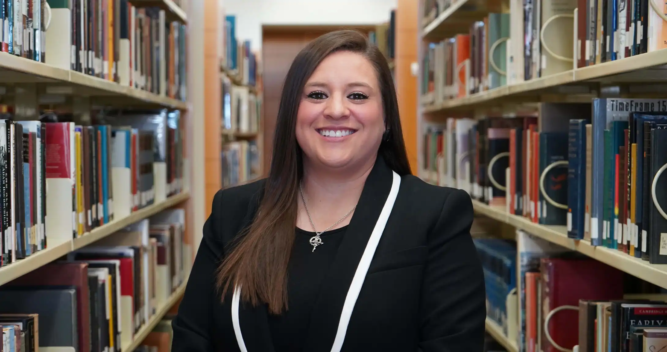 Ashley Salazar, UTPB graduate, standing in the on-campus library. 