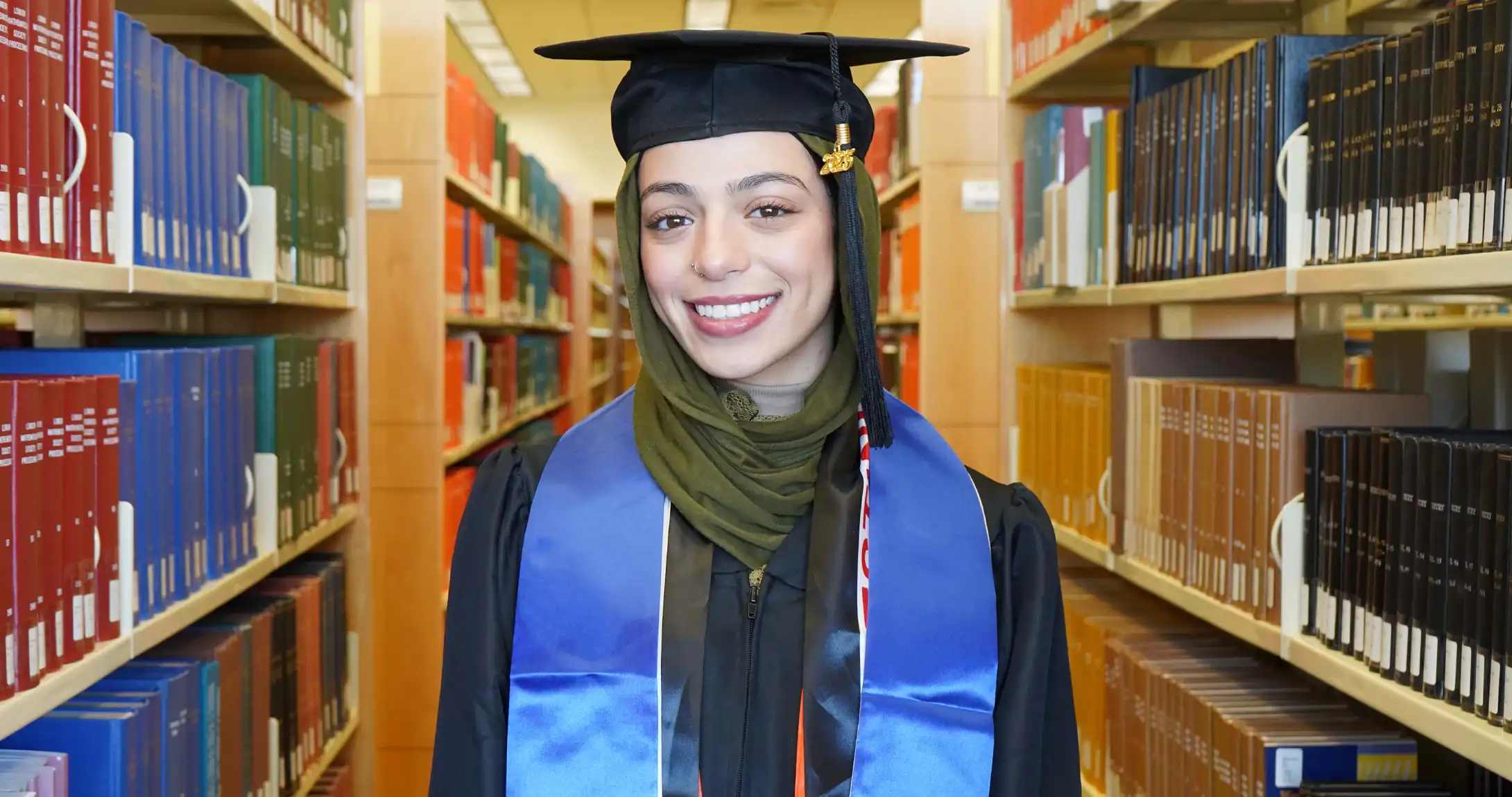 UTPB graduate, Fatema Nasser, in the on-campus library, 