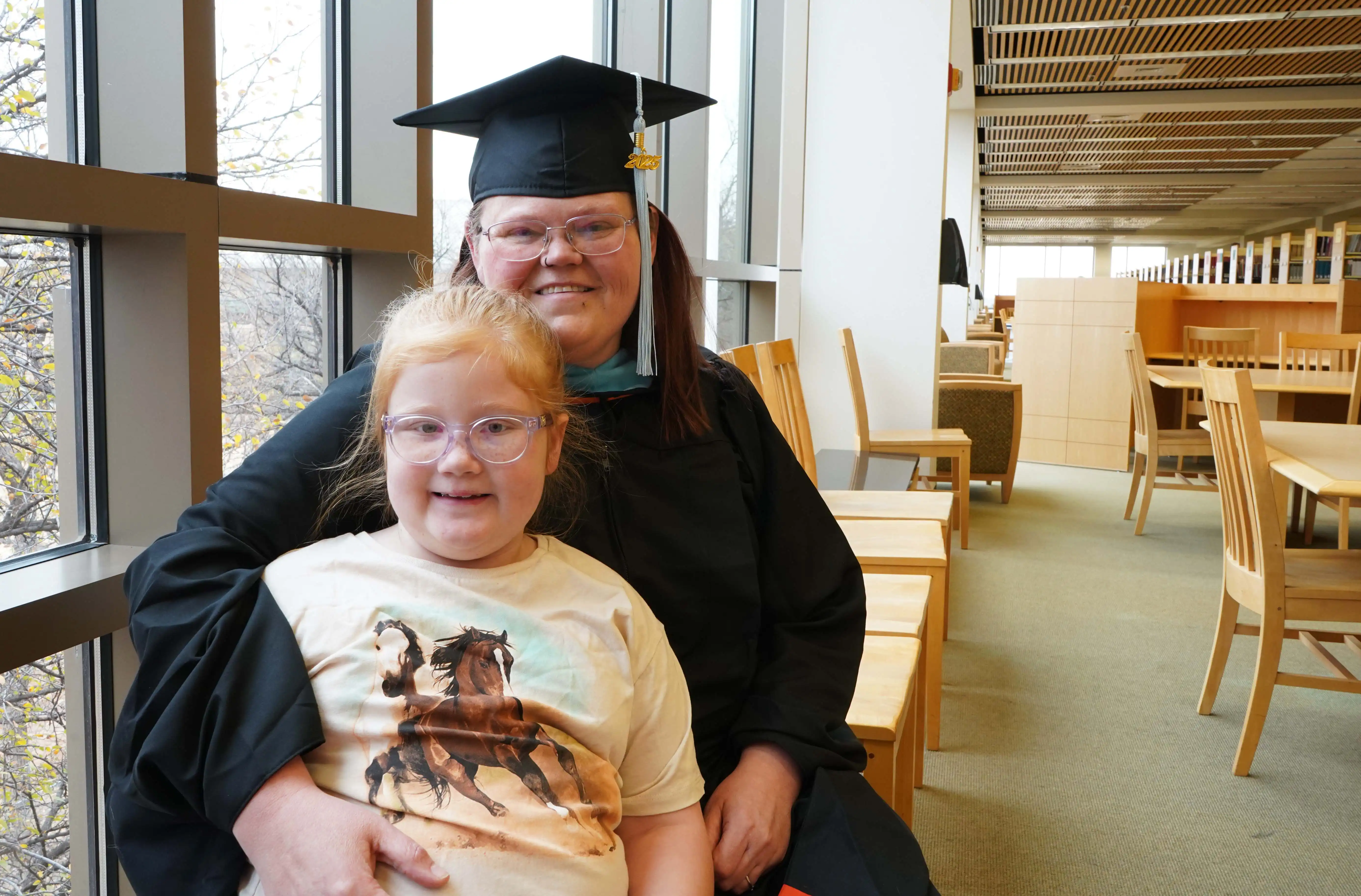 UTPB graduate, Kerri Shepherd, with her daughter in the on-campus library.