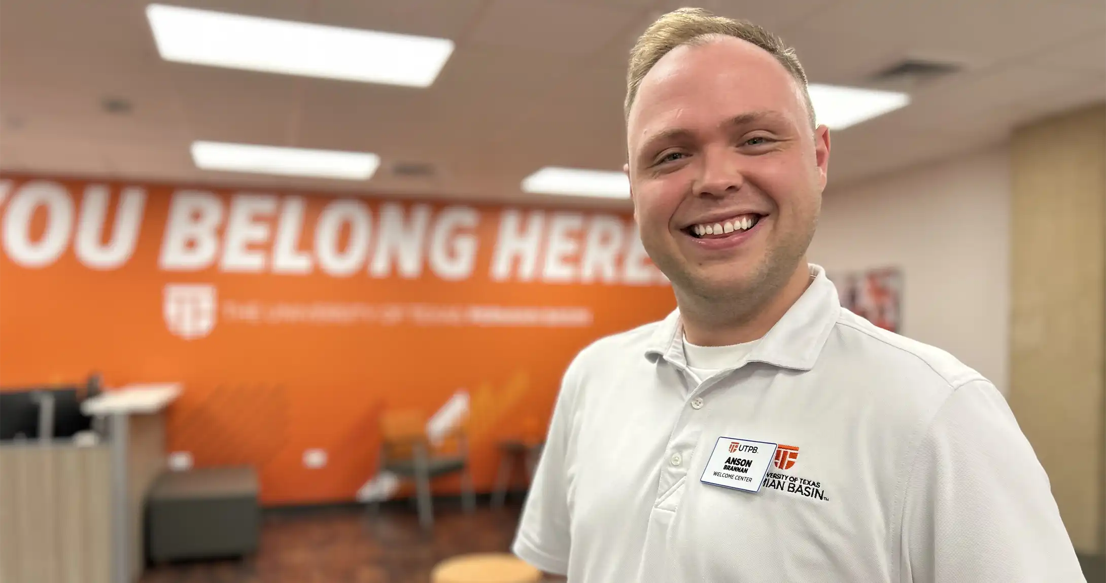 Anson Brannan standing and smiling in the Welcome Center on campus. 