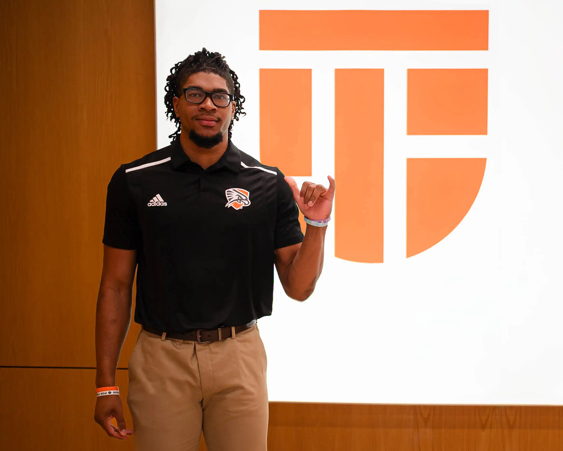 Ben Patterson standing in front of a UTPB sign in the Mesa. 