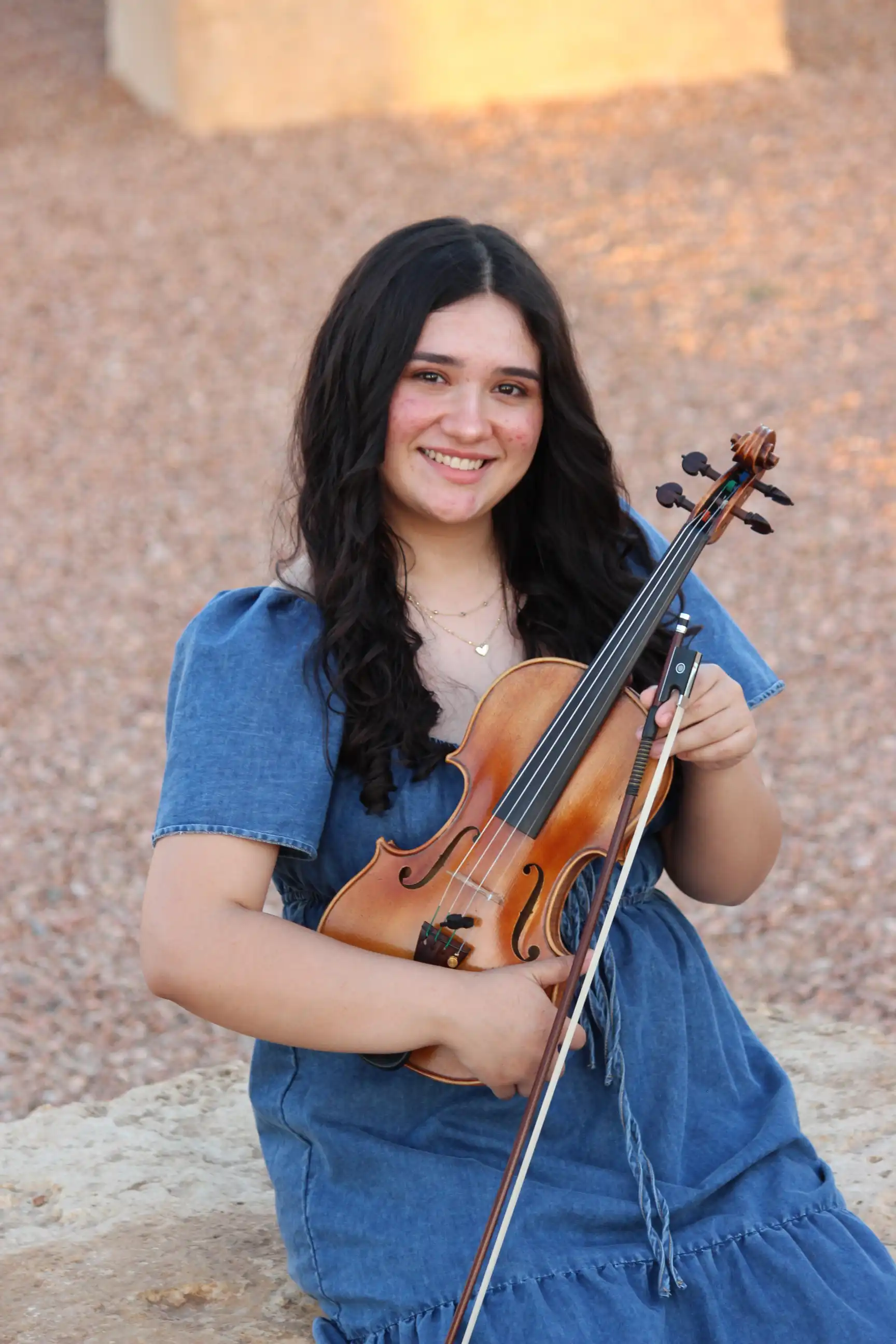 Daniela Salinas posing for a phot with her violin. 