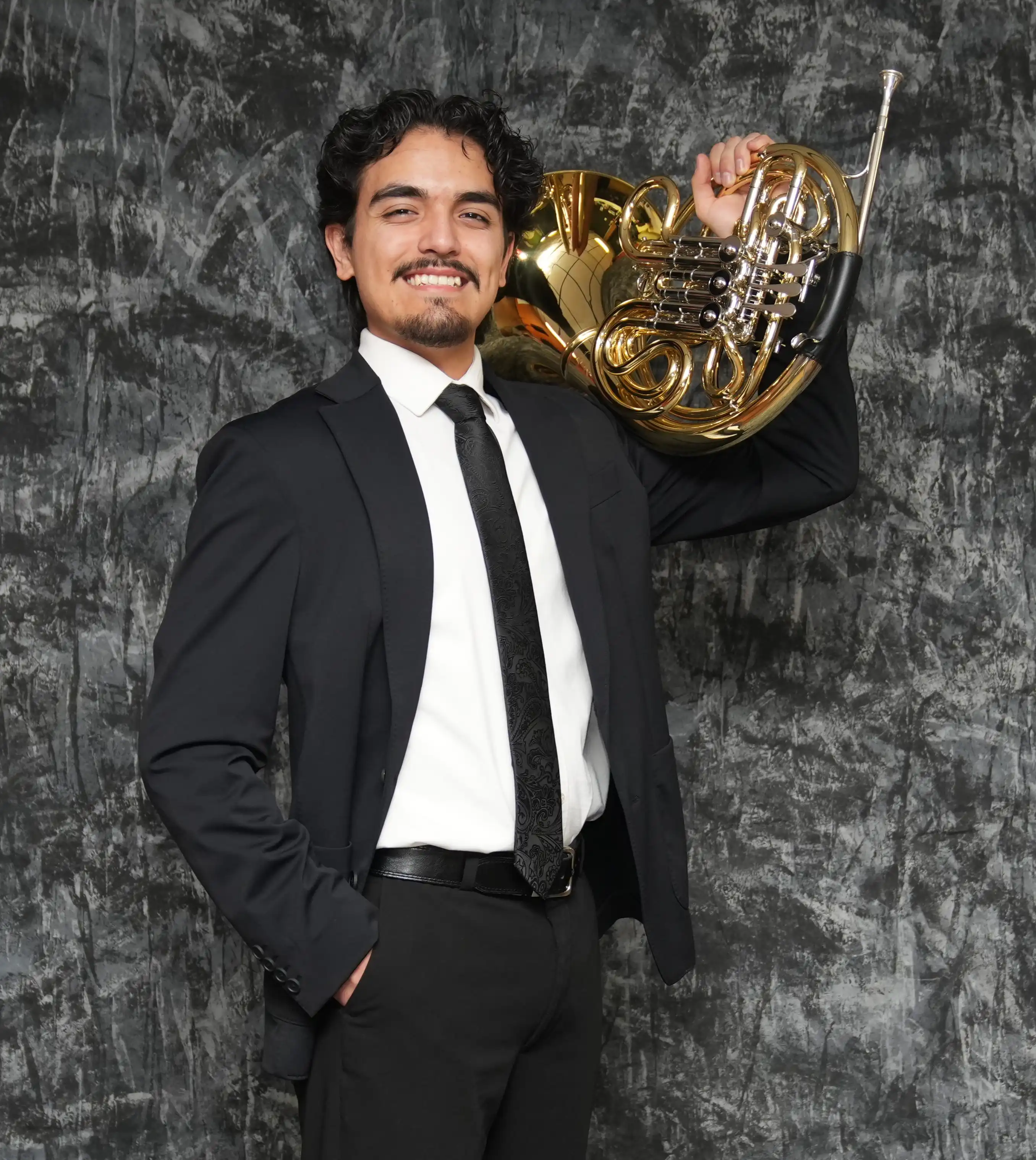 Steven martin posing for a photo with his French horn. 