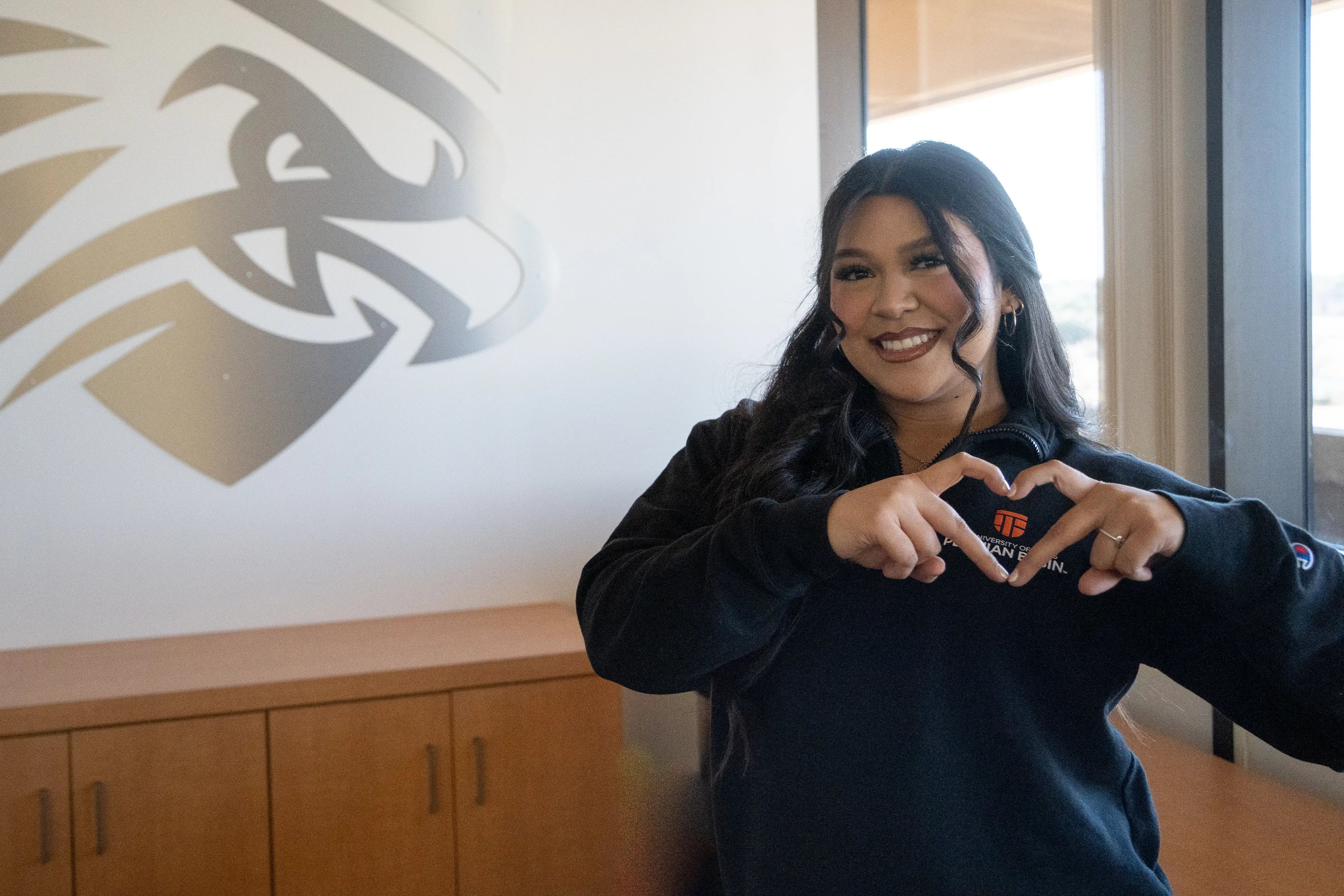 UTPB student holding up a heart for Falcon Giving Day. 