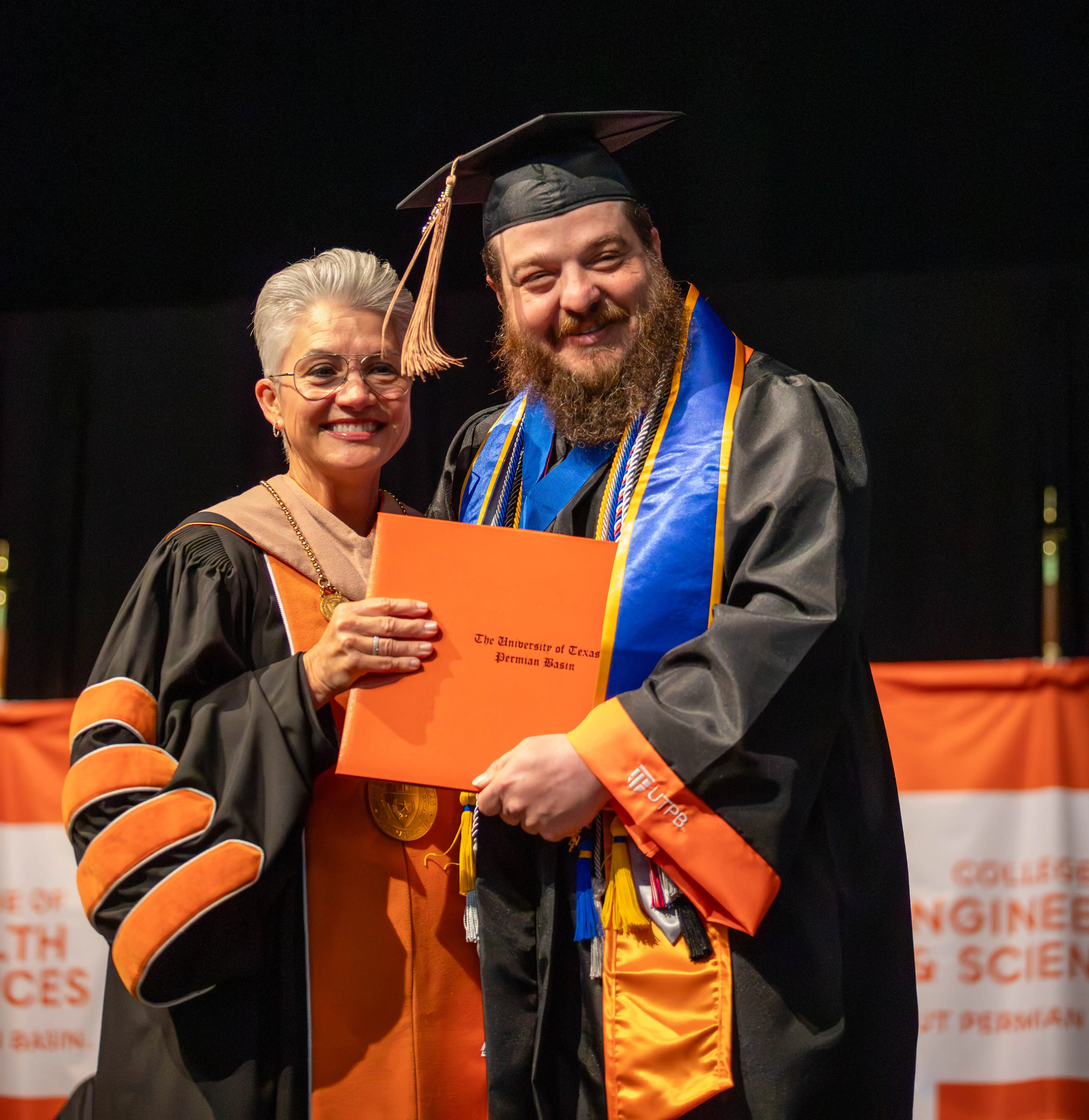 Bradley posing for a photo with President Woodley while walking the stage at graduation.