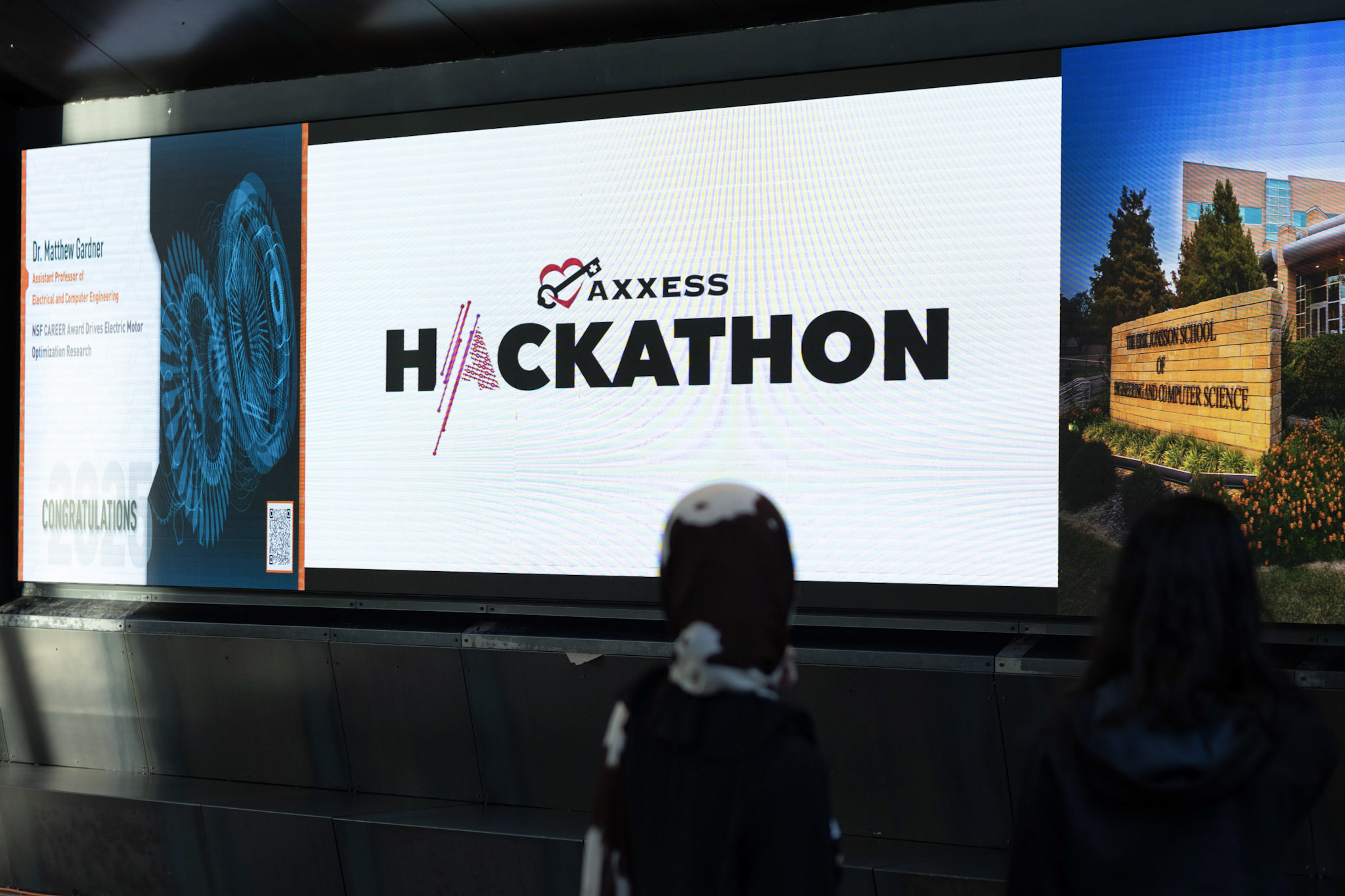 The Axxess Hackathon logo displayed on a large screen outside of the competition hall. 