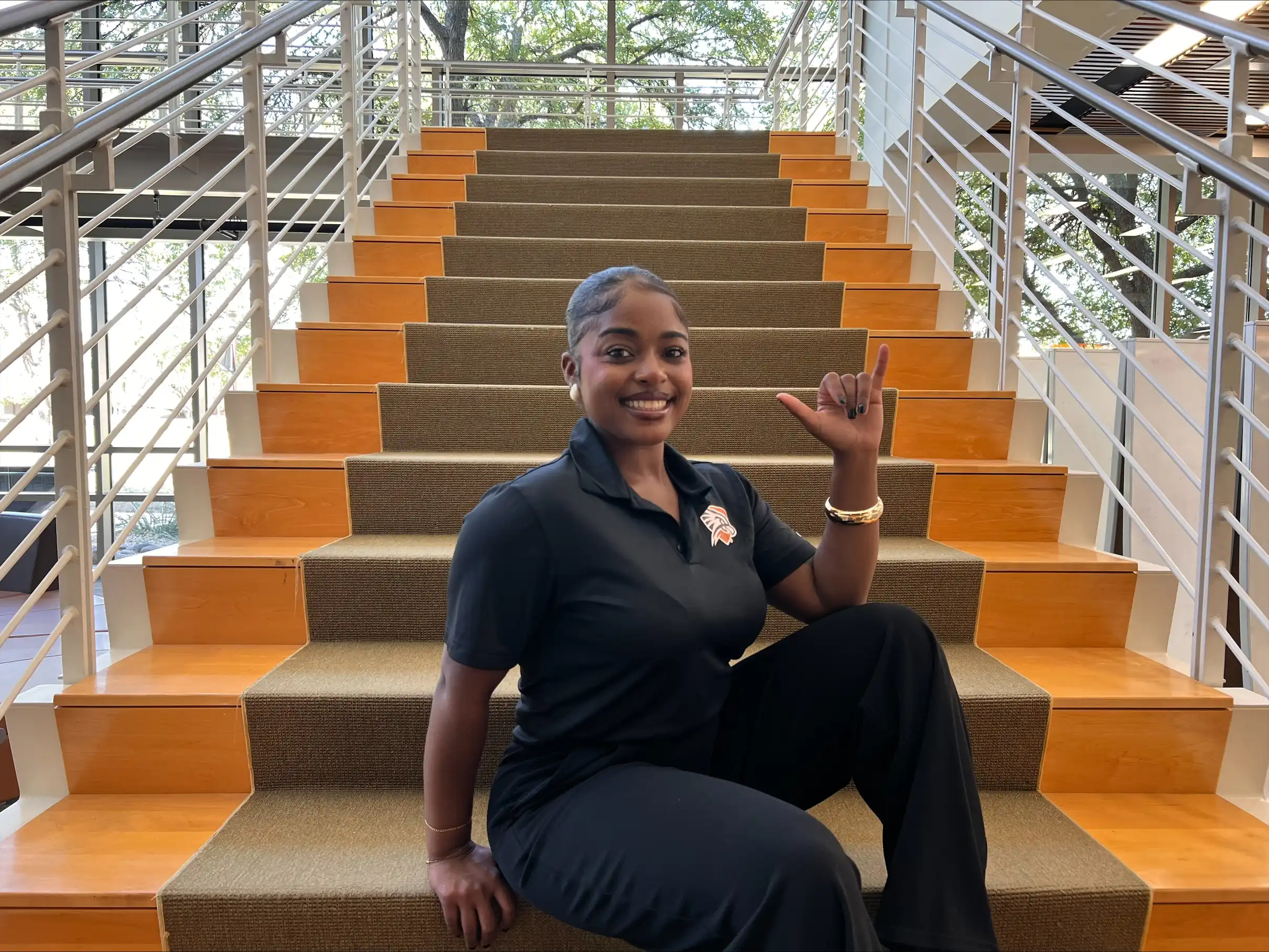 Javonnee Waiters holding her "Falcons Up" sign in the on-campus library. 