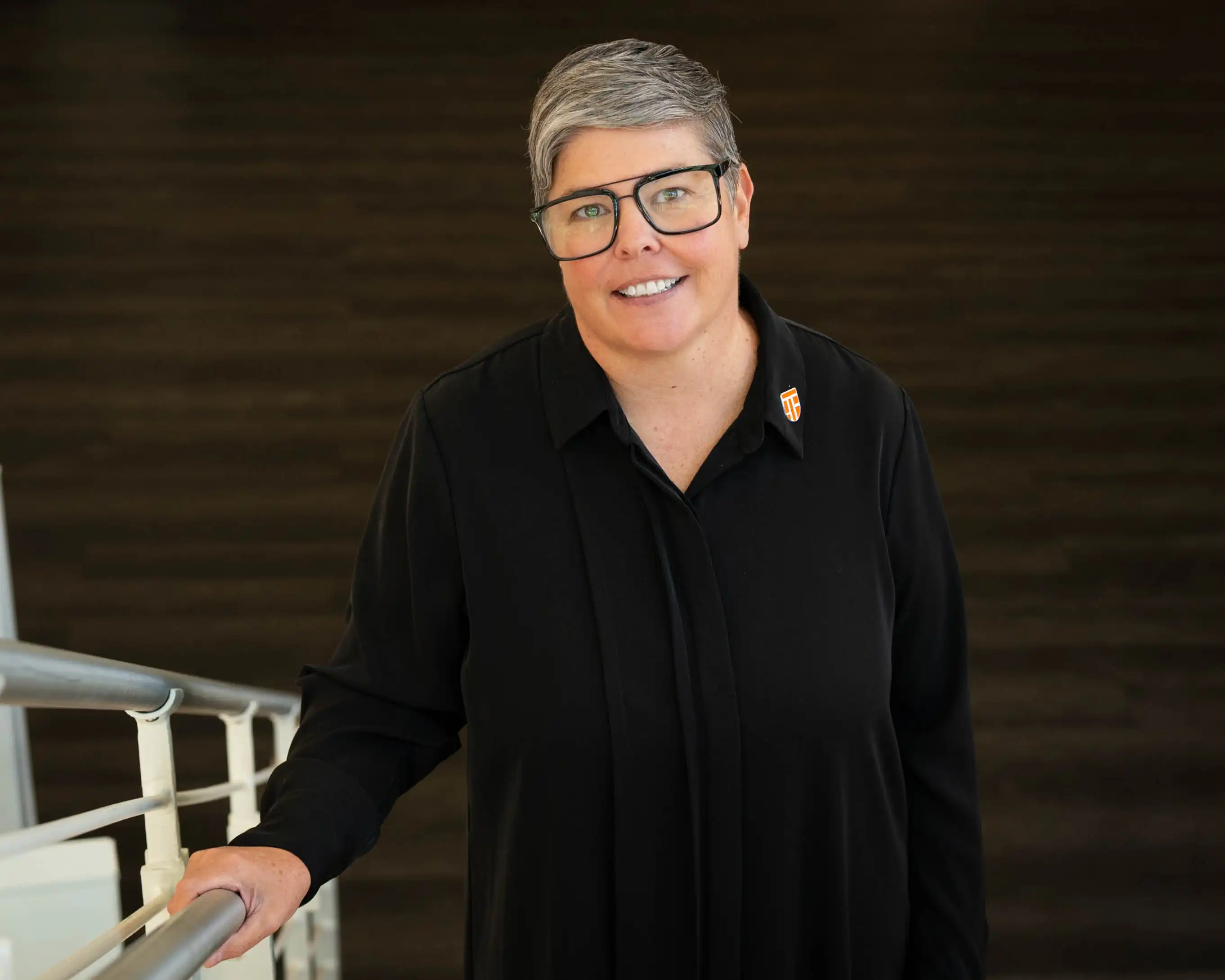 Jennifer Seybert standing on the stairs in the UTPB library. 