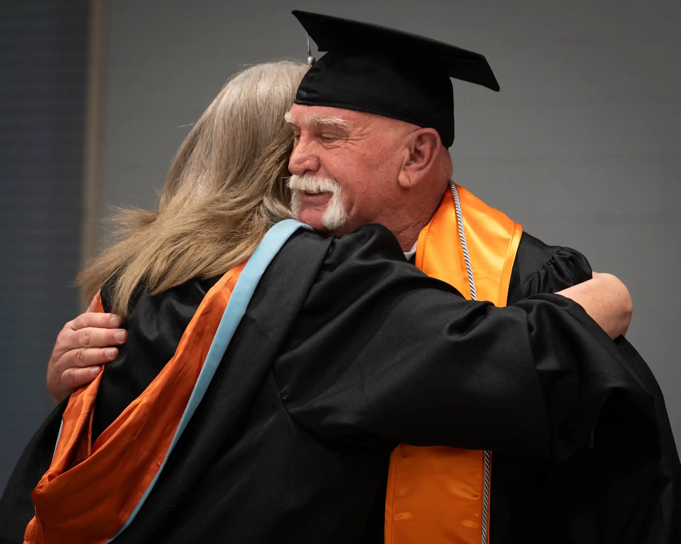 Larry Wallum hugging Marsha Bridges after walking the stage at UTPB's spring 2026 commencement. 