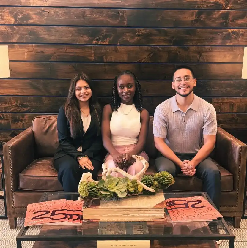 A photo of three UTPB students sitting on a couch at intern welcome party.