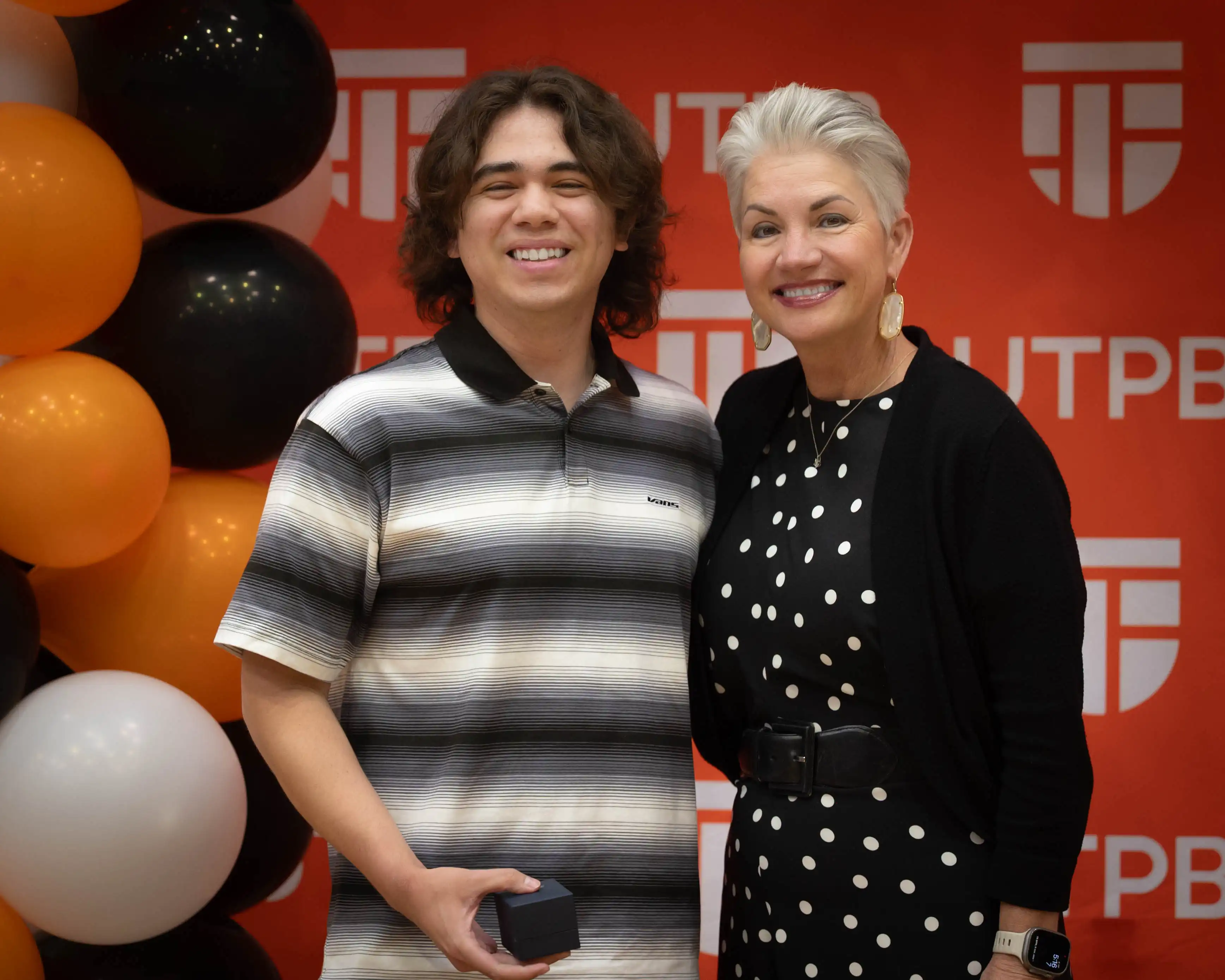 Recent graduate Ethan Cress posing for a photo with president Woodley after receiving her class ring. 