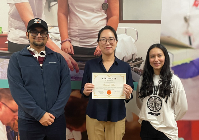 An image of the president and vide president of SGA awarding a faculty member the SGA faculty-staff of the week award.