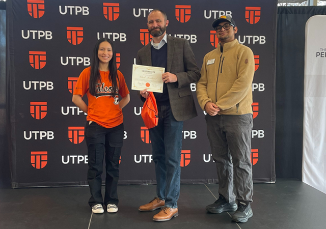 The Student Government Association President and Vice President presenting the faculty staff member of the week their award 