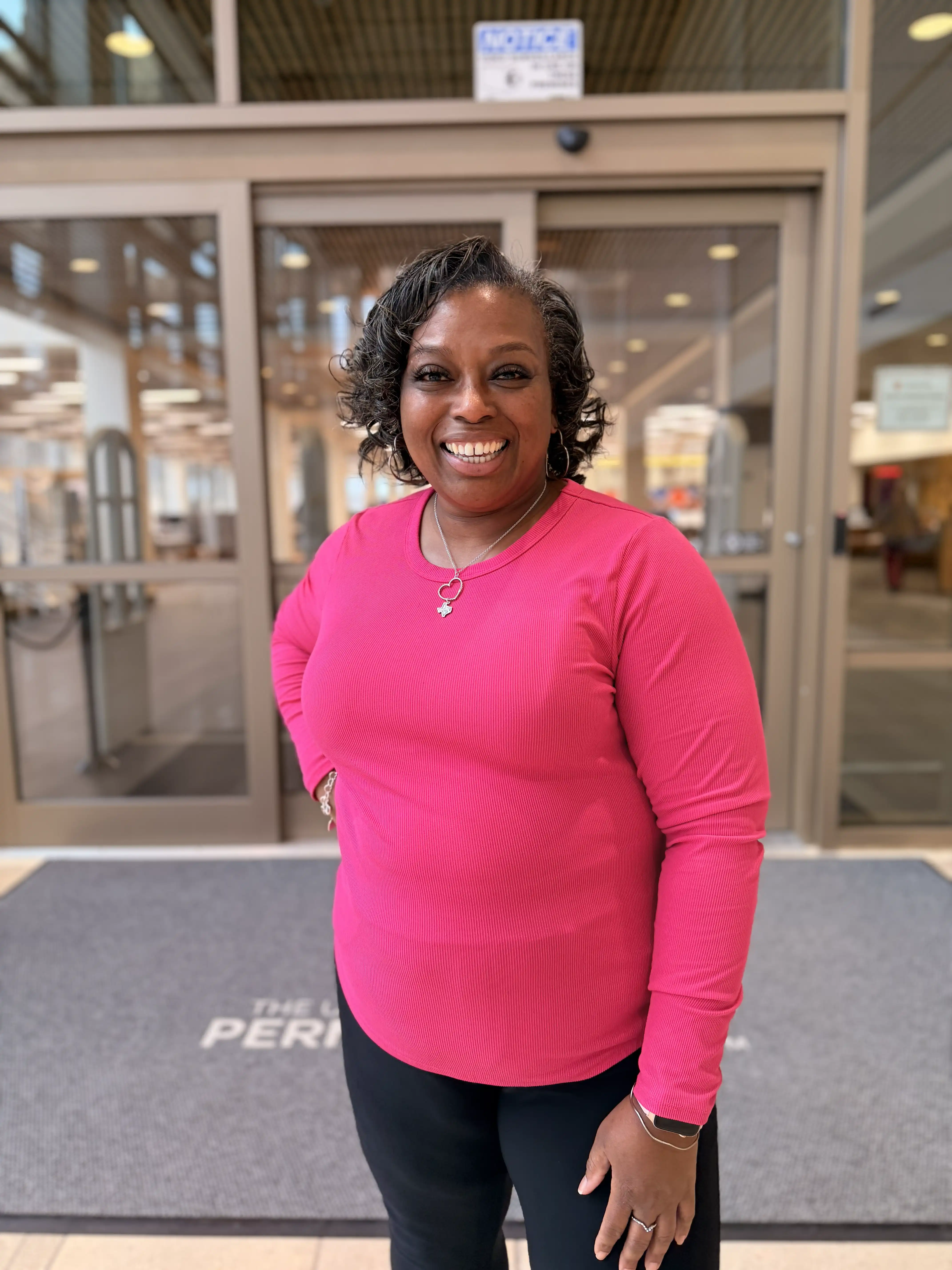 Sunnie Pope smiling in the library foyer. 