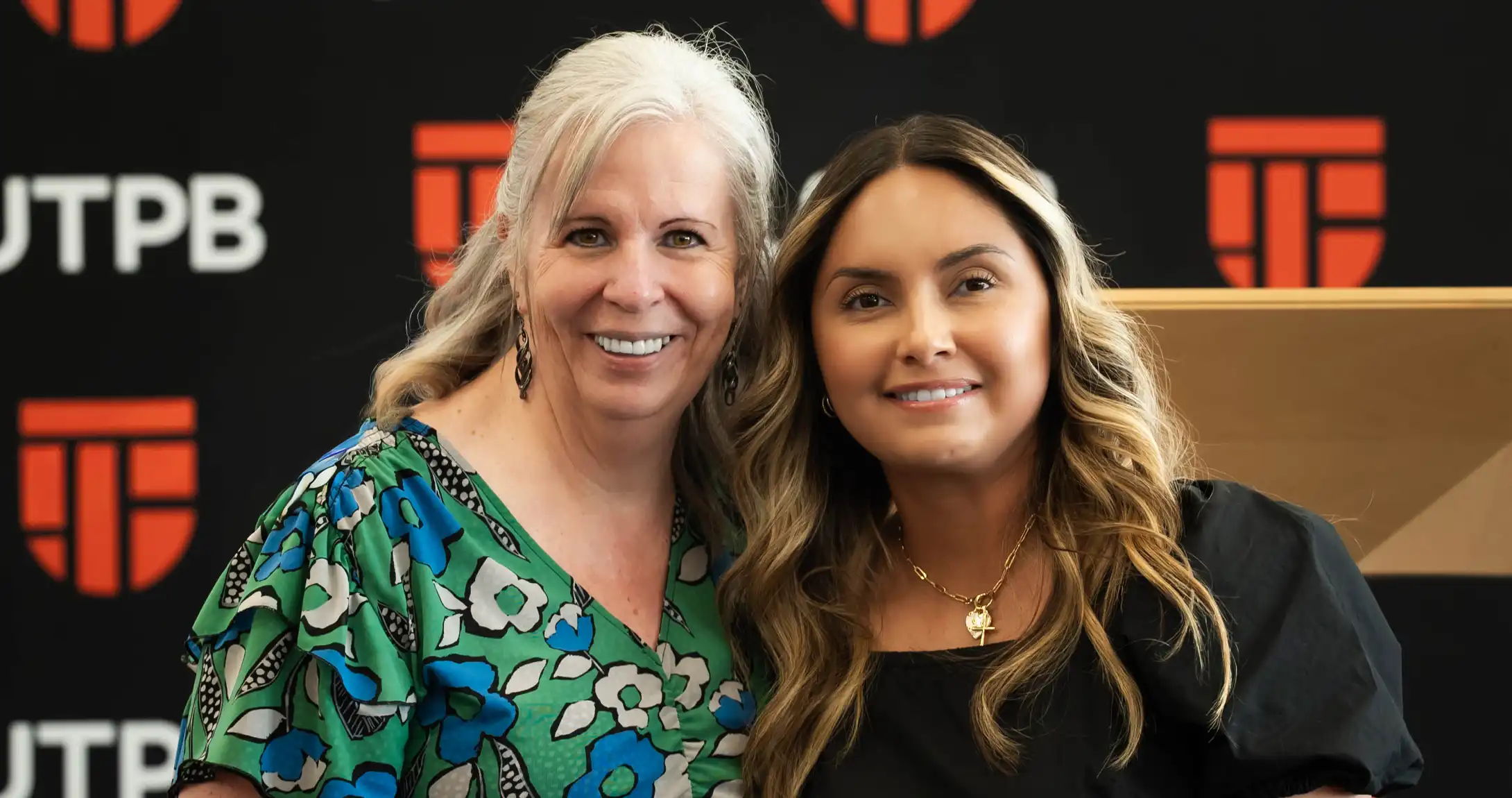 Marsha Bridges, left, standing with Vivian Galindo, right, at the Teacher Residency Program's Pinning Ceremony. 