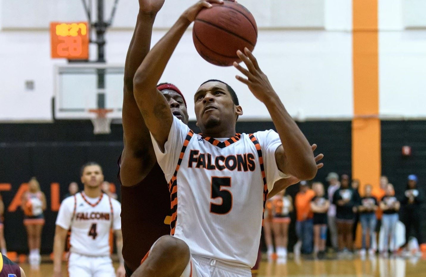 Men's basketball player goes in for a basket