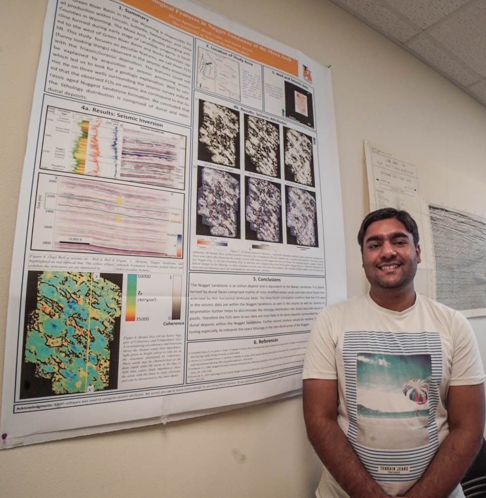 Dhruv Agrawal smiling next to his research