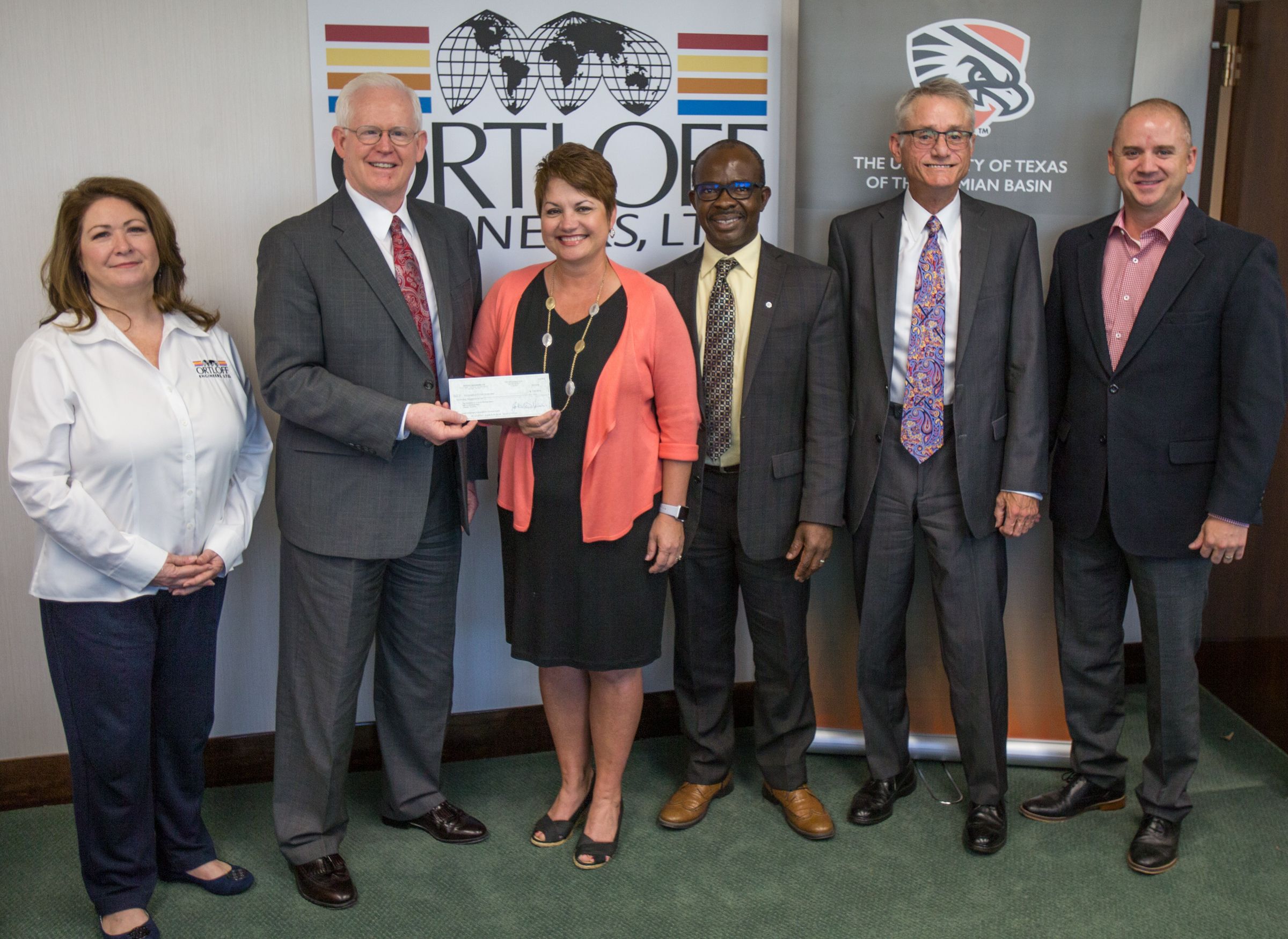 Dr. Woodley smiles and accepts check from Ortloff Engineers