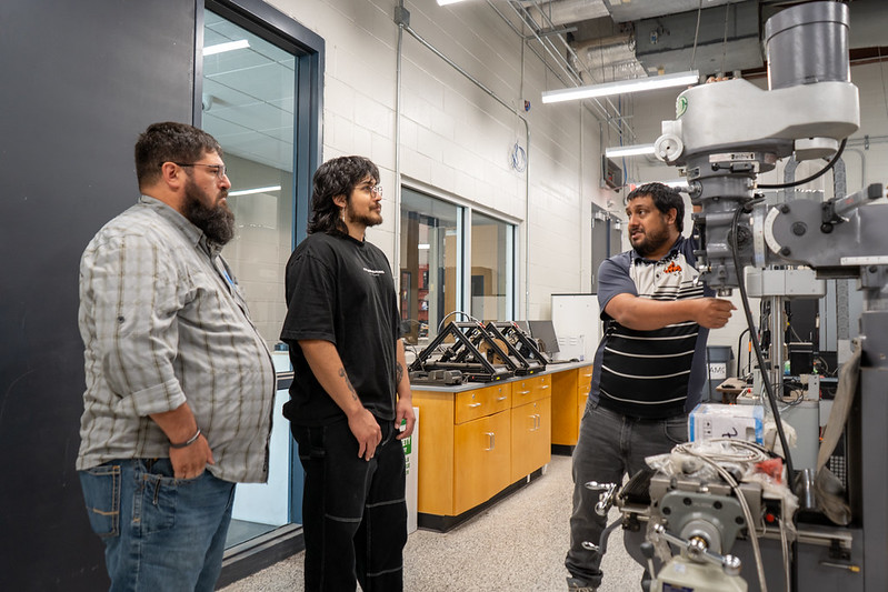 Image of people talking in front of mill